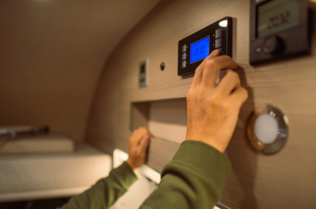 A man adjusting the interior RV camper van temperature.